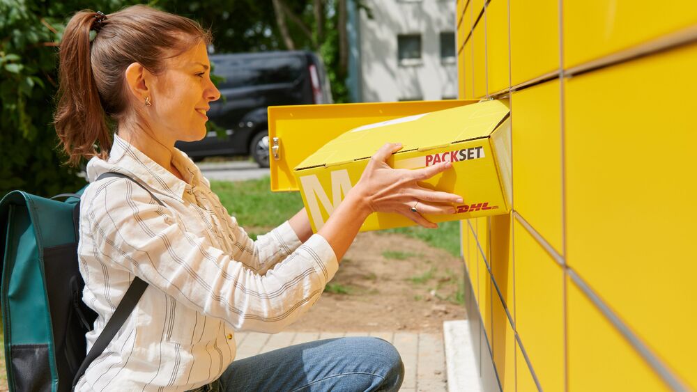 Eine Kundin verschickt ein Paket an einer Packstation  Foto: Andreas Oertzen / DHL Group